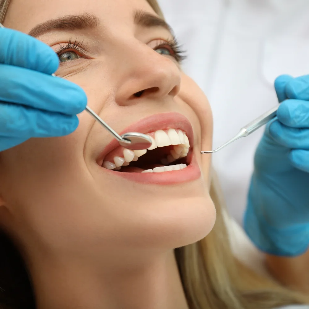 Patient receiving dental restoration treatment with dentist using dental instruments at Hanlon Creek Dental in Guelph
