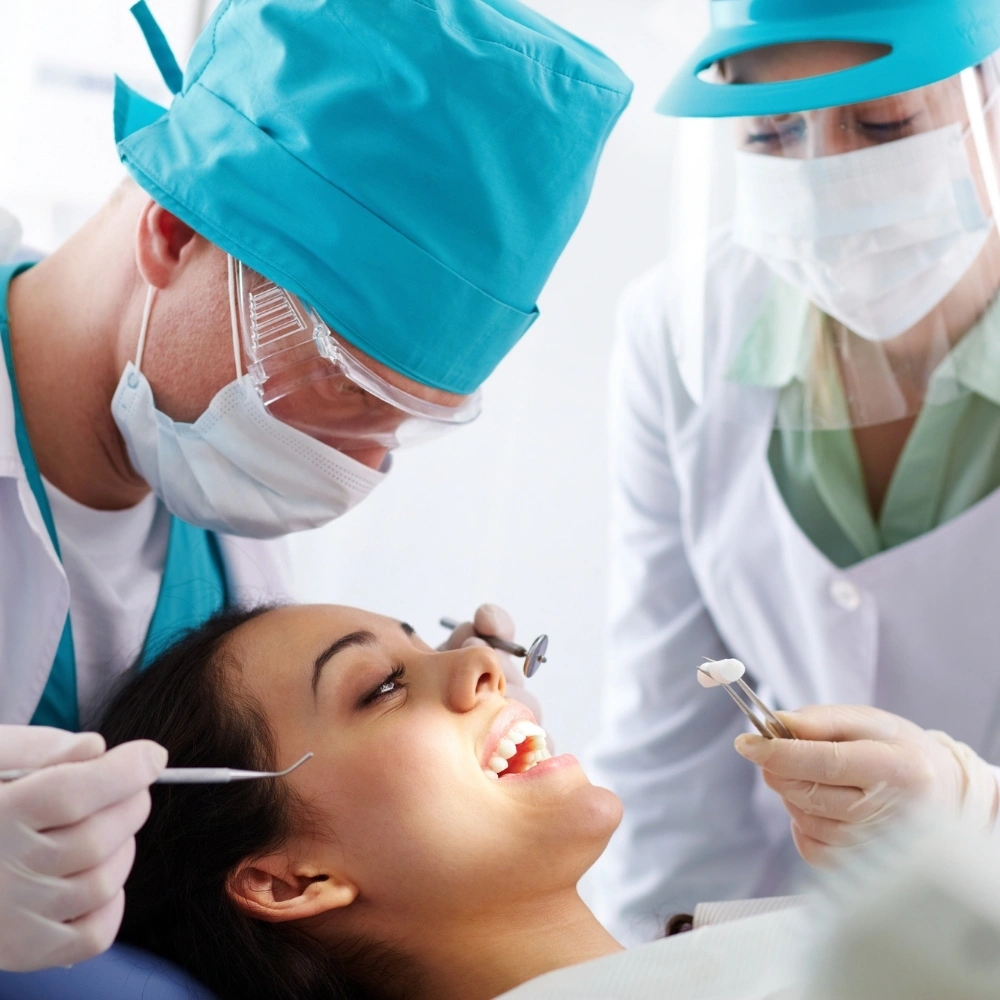 A dental team performing a comprehensive oral examination on a patient in the dental chair at Hanlon Creek Dental in Guelph, ON.