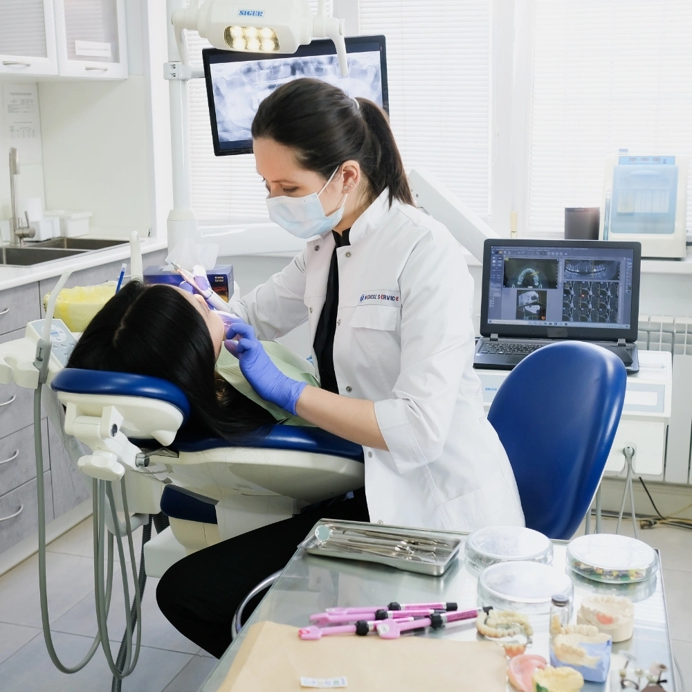 Dentist performing a procedure on a patient using modern dental equipment at Hanlon Creek Dental in Guelph, ON