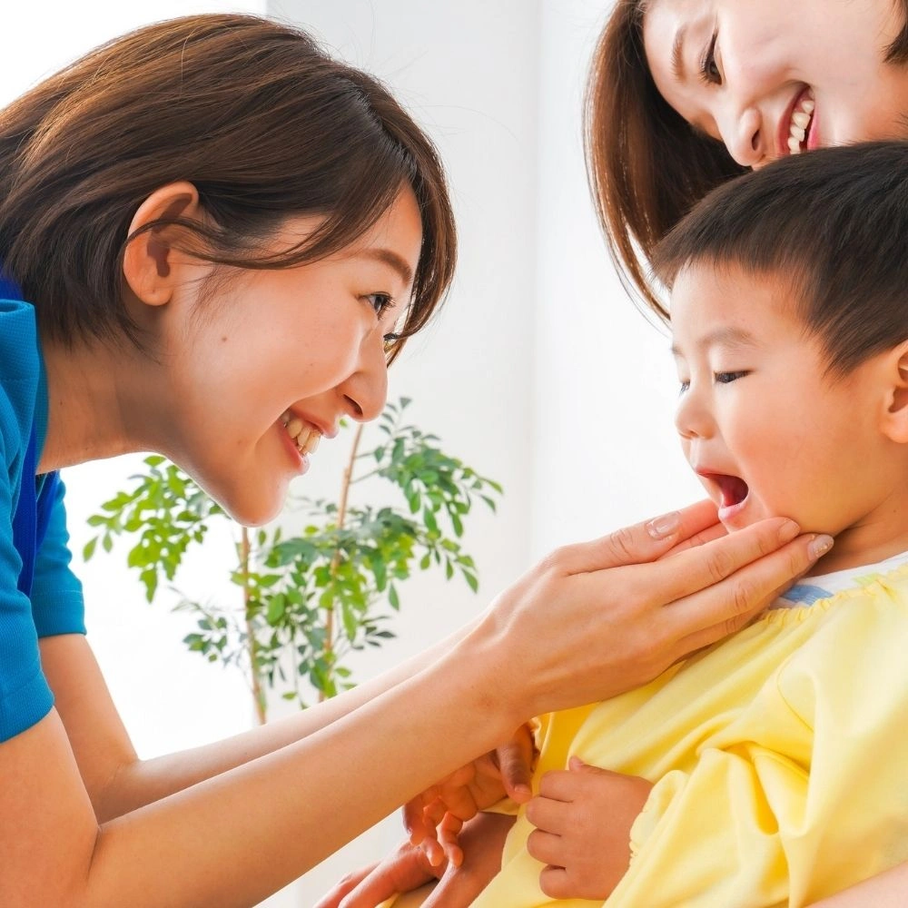 A pediatric dentist examines a young child’s mouth with a parent beside, at a Hanlon Creek Dental clinic in Guelph, promoting gentle kids’ dental care.