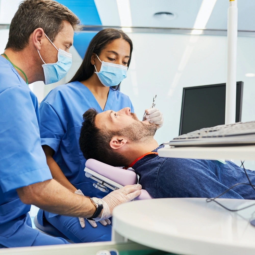 Orthodontic treatment appointment at Hanlon Creek Dental in Guelph, ON, with dentist and assistant adjusting braces for adult patient