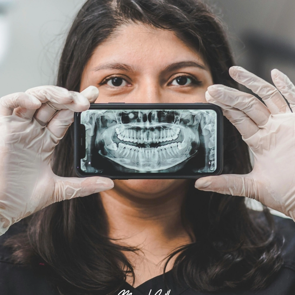 Patient holding a digital panoramic dental X-ray on a smartphone, demonstrating modern diagnostic technology at Hanlon Creek Dental in Guelph.