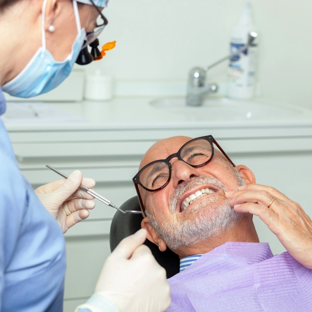 Elderly male patient experiencing severe tooth pain during emergency dental visit at Hanlon Creek Dental in Guelph, ON