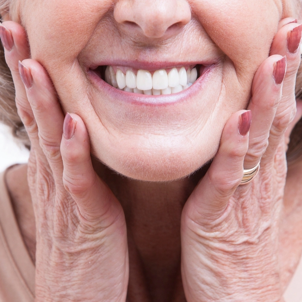 Senior patient smiling confidently with new dentures after treatment at Hanlon Creek Dental in Guelph
